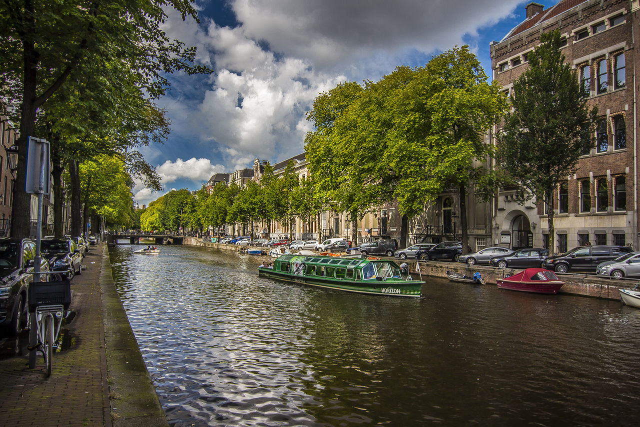 Green canal: Boat in Amsterdam canal